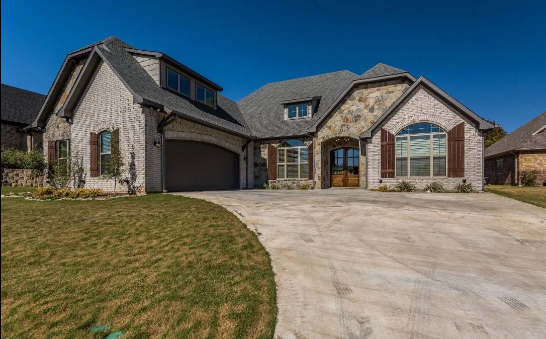 Beautiful stone home with big driveway.