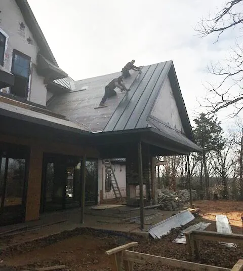 Two men adding roofing